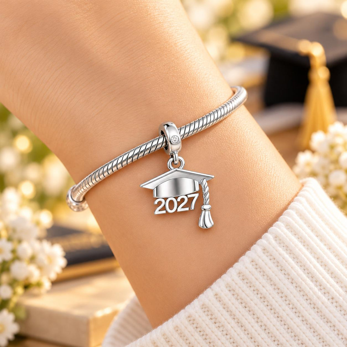 2027 graduation charm worn on a silver bracelet
