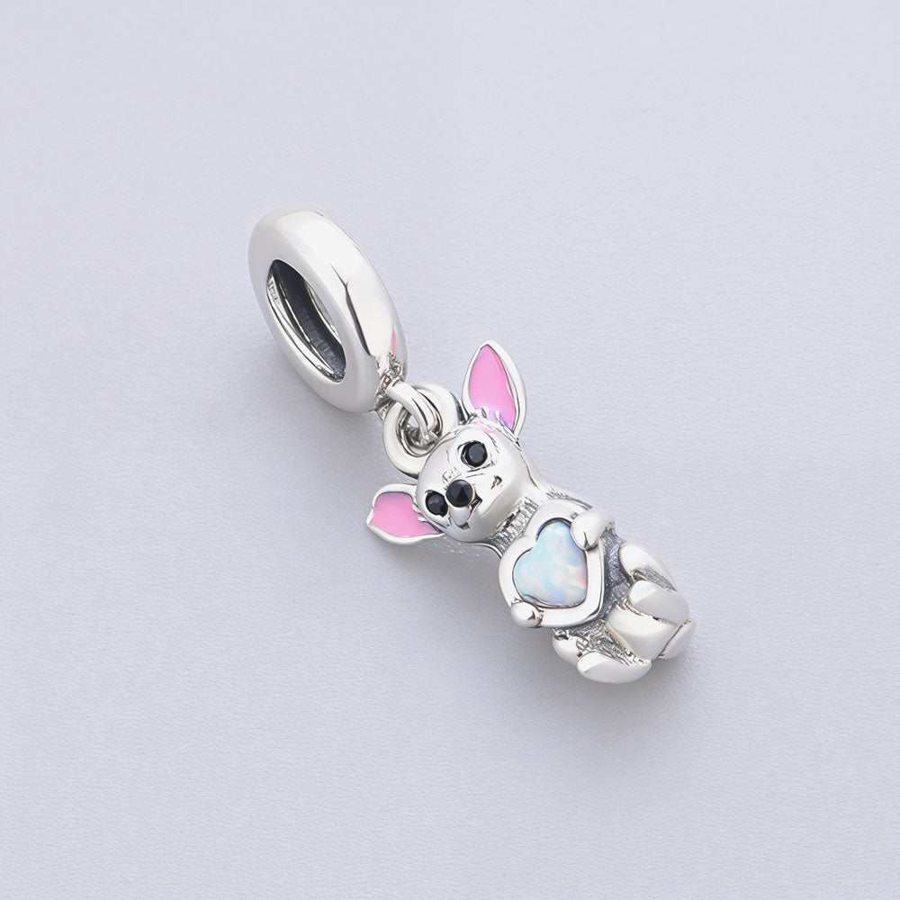 Close-up of a Chihuahua dog charm with a pink enamel ear and opal heart